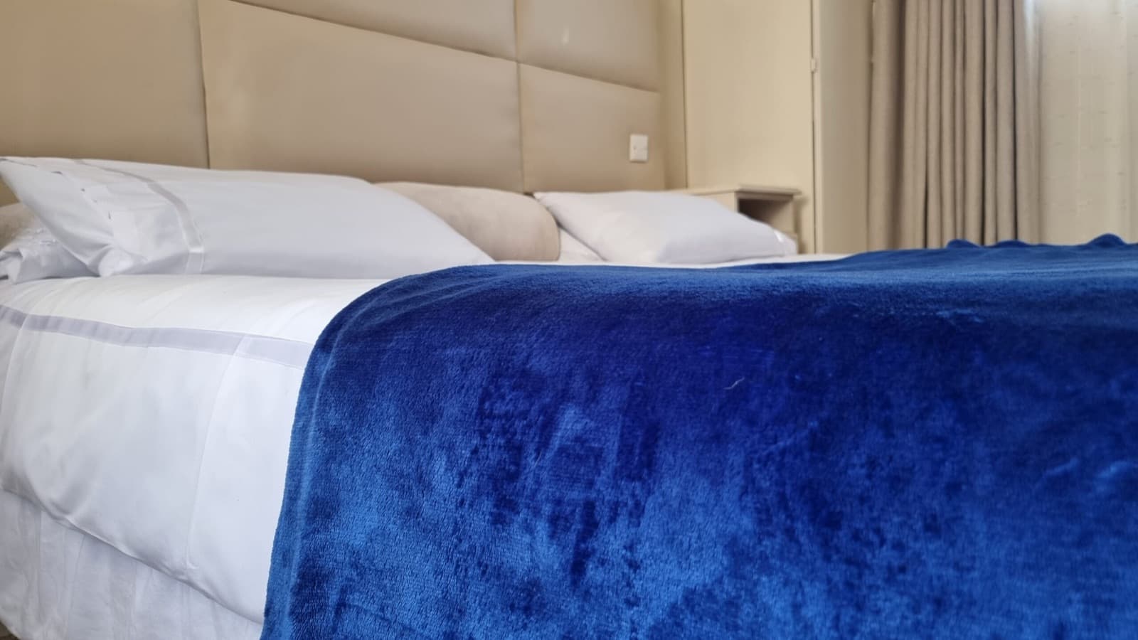 Deluxe room with a king bed and royal blue throw