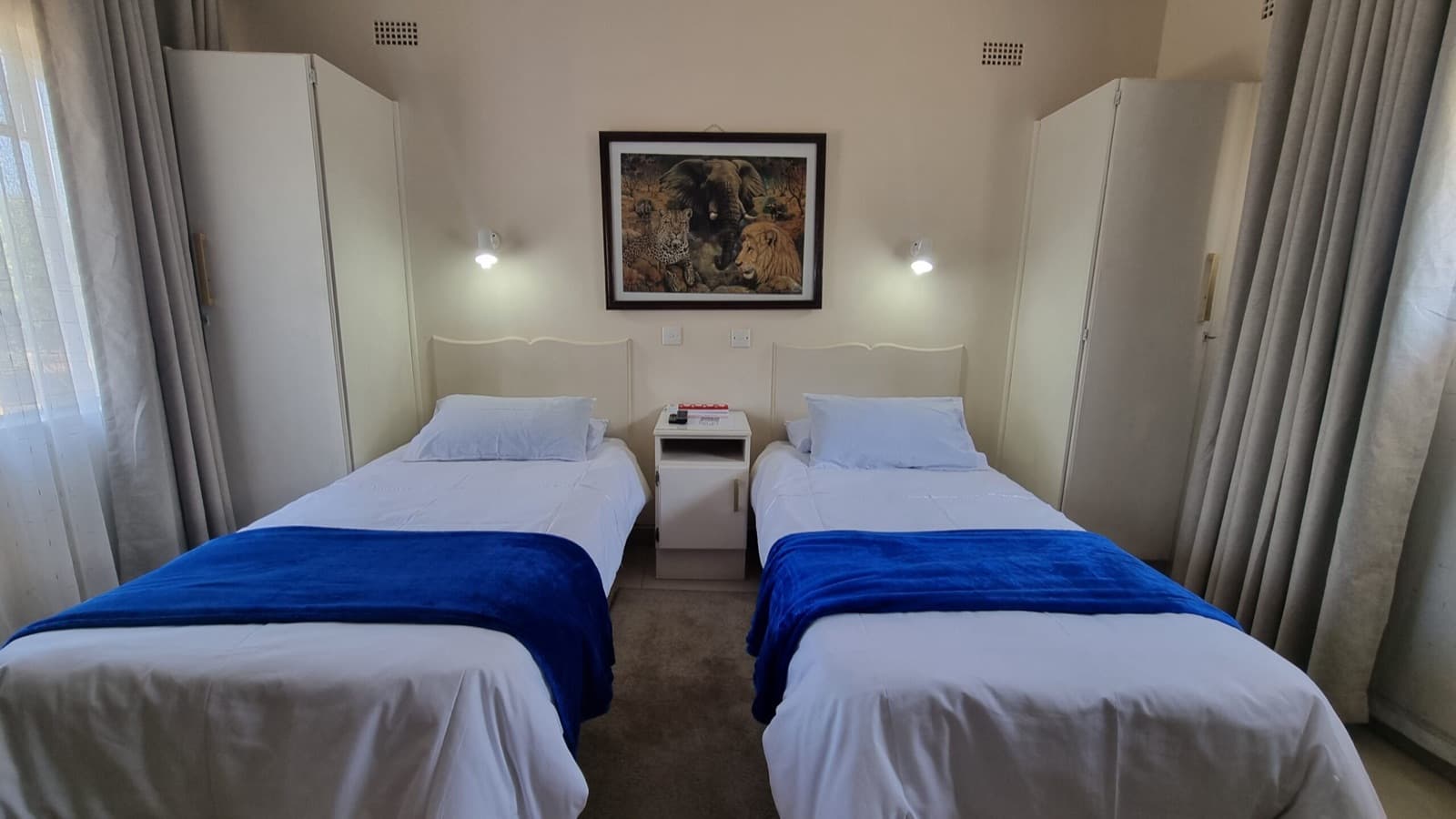 Twin room with two single beds and blue throws